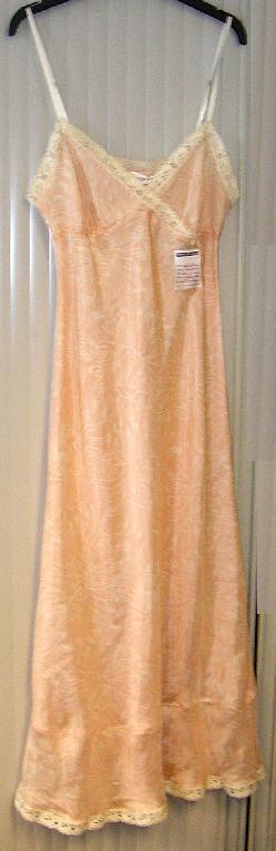 CHEMISE DE NUIT POUR FEMMES EN TISSU DE SOIE, IMPRIMÉ DE MOTIFS FLEURIS, TRANSLUCIDE, DE COUPE SIMPLE ET AMPLE, DESCENDANT JUSQU'AUX CHEVILLES.

CETTE CHEMISE DE NUIT PRÉSENTE UNE ENCOLURE TRÈS DÉCOLLETÉE CONSTITUÉE DE DEUX PANNEAUX QUI SE SUPERPOSENT SUR LE DEVANT DROITE SUR GAUCHE EN FORME DE CACHE-COEUR, COUSUS ENSEMBLE À LA BASE (SOUS LA POITRINE), DE FINES BRETELLES RÉGLABLES, UN PETIT NOEUD DÉCORATIF SITUÉ SOUS LA POITRINE CÔTÉ GAUCHE ET UNE BANDE DE TISSU VOLANTÉE RAPPORTÉE À LA BASE.

LE POURTOUR DU DÉCOLLETÉ, DES EMMANCHURES ET DU DOS AINSI QUE LA BASE SONT BORDÉS D'UN GALON UNICOLORE CONFECTIONNÉ EN CROCHET.