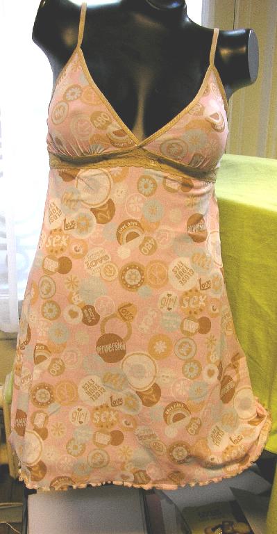 COMBINAISON POUR FEMMES EN BONNETERIE DE FIBRES SYNTHÉTIQUES (100% NYLON), IMPRIMÉE, LÉGÈREMENT TRANSLUCIDE, DESCENDANT JUSQU'À LA MI-CUISSE ET PRÉSENTANT UN PROFOND DÉCOLLETÉ EN V BORDÉ PAR UN GALON DE COULEUR CONTRASTÉE QUI SE PROLONGE PAR DE FINES BRETELLES, UNE BANDE DE DENTELLE DE COULEUR CONTRASTÉE RAPPORTÉE SOUS LA POITRINE ET UNE BASE SURFILÉE.