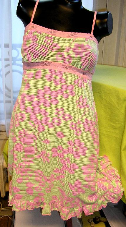 COMBINAISON POUR FEMMES EN BONNETERIE DE FIBRES SYNTHÉTIQUES (83% NYLON - 17% ÉLASTHANNE), IMPRIMÉE DE MOTIFS FLEURIS, LÉGÈREMENT TRANSLUCIDE, DESCENDANT JUSQU'À MI-CUISSE ET COMPORTANT DE FINES BRETELLES, UNE ENCOLURE DROITE BORDÉE D'UNE BANDE DE DENTELLE UNICOLORE SUR TOUT SON POURTOUR ET UNE BANDE DE DENTELLE IDENTIQUE RAPPORTÉE SOUS LA POITRINE.

EN OUTRE ELLE PRÉSENTE UNE BANDE DE BONNETERIE VOLANTÉE RAPPORTÉE À LA BASE.