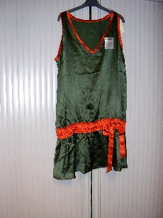 VETEMENT DESTINE A RECOUVRIR LA PARTIE SUPERIEURE DU CORPS, GENRE BLOUSE, POUR FEMME, EN TISSU 100% SOIE, DE FORME EVASEE, SANS MANCHES, COMPORTANT UNE ENCOLURE EN V, DE LARGES EMMANCHURES, UN ELASTIQUE A LA TAILLE, UN OURLET A LA BASE, DECORATION PETIT VOLANT  LE LONG DES BORDURES DE L'ENCOLURE, ET DES EMMANCHURES, SMOCKS BRODES TOUT LE LONG DE L'ELASTIQUE AUTOUR DE LA TAILLE AVEC UN RUBAN A NOUER.