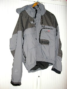 VETEMENT DESTINE A RECOUVRIR LA PARTIE SUPERIEURE DU CORPS, GENRE BLOUSON, EN TISSU 100% POLYAMIDE AVEC UNE ENDUCTION 100% POLYURETHANNE VISIBLE A L'OEIL NU, POUR HOMME, COMPORTANT UN COL MONTANT PROLONGE D'UNE CAPUCHE A VISIERE AVEC UN CORDON RESSERRANT REGLABLE, UNE OUVERTURE COMPLETE SUR LE DEVANT AU MILIEU AVEC UNE FERMETURE A GLISSIERE ET UNE PATTE DE PROTECTION AVEC BANDES VELCRO SE REFERMANT DE GAUCHE SUR DROITE, DES MANCHES LONGUES DONT LES EXTREMITES SE RESSERRENT PAR BANDES VELCRO, UNE PETITE POCHE AVEC FERMETURE A GLISSIERE SUR LE HAUT DE LA MANCHE GAUCHE, UNE GRANDE OUVERTURE AVEC FERMETURE A GLISSIERE DE CHAQUE COTE DU VETEMENT, UNE GRANDE POCHE A SOUFFLET AVEC RABAT CONTENANT DEUX AUTRES PETITES POCHES AVEC FERMETURE PAR BANDES VELCRO COTE DROIT DE LA POITRINE, UNE GRANDE POCHE A SOUFFLET AVEC FERMETURE A GLISSIERE ET PORTE STYLO COTE GAUCHE DE LA POITRINE, UNE OUVERTURE AVEC FERMETURE A GLISSIERE DANS LE BAS DU DOS, LA BASE DU VETEMENT EST ELASTIQUEE AVEC UN CORDON RESSERRANT, DOUBLURE 100% POLYESTER AVEC POCHE A FERMETURE A GLISSIERE COTE DROIT ET UNE POCHE MAILLES FILET DE CHAQUE COTE, TISSU RENFORCE AUX COUDES, AUX EPAULES, EN HAUT DE LA POITRINE ET DU DOS, LOGO PUBLICITAIRE BRODE SUR LA POCHE POITRINE GAUCHE.