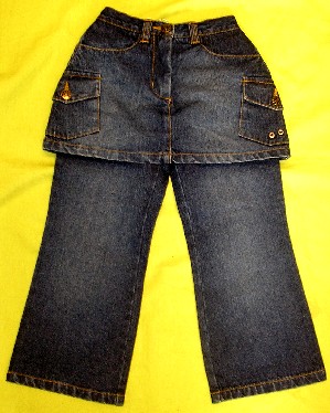 VÊTEMENT COMPOSITE POUR FILLETTES MAJORITAIREMENT EN TISSU DE COTON (97% COTON - 3% ÉLASTHANE), DIT DE "DENIM", COMPOSÉ D'UNE JUPE ET D'UN PANTALON COUSUS ENSEMBLE AU NIVEAU DE LA TAILLE ET DE L'ENTREJAMBE :

- LE PANTALON EST DE COUPE DROITE, DESCEND JUSQU'AUX CHEVILLES ET PRÉSENTE UN OURLET À L'EXTRÉMITÉ DES JAMBES.

- LA JUPE EST DE FORME TRAPÈZE ET DESCEND JUSQU'AU-DESSUS DE LA MI-CUISSE. ELLE PRÉSENTE UNE TAILLE ÉLASTIQUÉE DANS LE DOS, DES PASSANTS POUR CEINTURE, UNE OUVERTURE PARTIELLE SUR LE DEVANT SE FERMANT DROITE SUR GAUCHE PAR UNE FERMETURE À GLISSIÈRE RECOUVERTE D'UNE PATTE BOUTONNÉE, DEUX POCHES LATÉRALES SOUS LA TAILLE, DEUX POCHES PLAQUÉES À RABAT BOUTONNÉ SUR LES CUISSES ET UN OURLET À LA BASE.