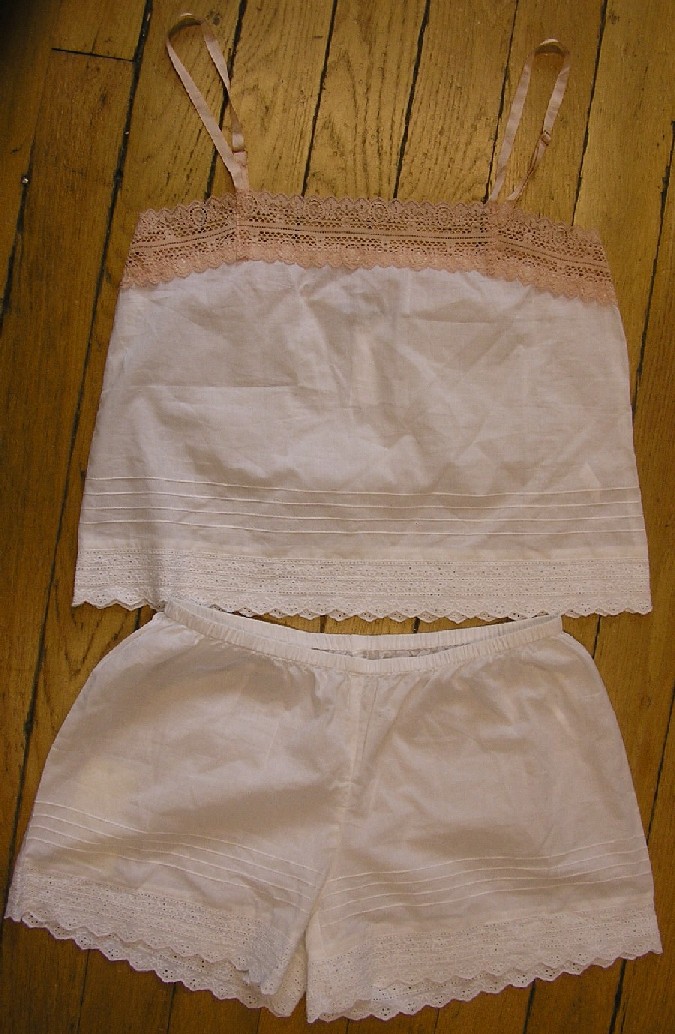PYJAMA POUR FEMMES CONFECTIONNÉ EN TISSU MAJORITAIREMENT DE COTON (89% COTON, 9% POLYAMIDE ET 2% ELASTHANNE), COMPOSÉ DE DEUX PARTIES ASSORTIES DANS LES TAILLES, LES COLORIS ET LE DEGRÉ DE FINITION, QUI SONT:

- UN VÊTEMENT DESTINÉ À RECOUVRIR LA PARTIE SUPÉRIEURE DU CORPS, GENRE BLOUSE, DESCENDANT JUSQU'AUX HANCHES, AVEC UNE ENCOLURE DROITE LÉGÈREMENT DÉGAGÉE, AVEC UNE BANDE GENRE DENTELLE ÉLASTIQUE DE COULEUR CONTRASTÉE COUSUE SUR TOUT LE POURTOUR DE L'ENCOLURE , AVEC DE FINES BRETELLES DE LA MÊME COULEUR QUE LA DENTELLE, AVEC UNE BASE BRODÉE.

- UN VÊTEMENT DU TYPE SHORT, DESCENDANT JUSQU'À MI-CUISSE, AVEC UNE TAILLE ÉLASTIQUÉE, AVEC LE BAS DES JAMBES BRODÉ.