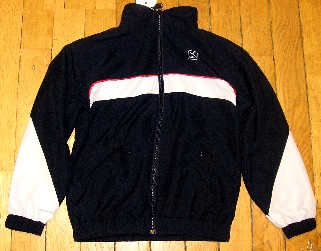 SURVÊTEMENT DE SPORT EN TISSU DE FIBRES SYNTHÉTIQUES (100% POLYESTER), NON RECONNAISSABLE COMME ÉTANT POUR GARÇONS OU POUR FILLES, COMPOSÉ D'UNE VESTE ET D'UN PANTALON :

- LA VESTE DESCEND JUSQU'AUX HANCHES ET COMPORTE UN COL MONTANT, UNE OUVERTURE COMPLÈTE SUR LE DEVANT SE FERMANT AU MOYEN D'UNE FERMETURE À GLISSIÈRE, UNE DOUBLURE COMPLÈTE EN MAILLES FILET, DES MANCHES LONGUES RESSERRÉES À LEUR EXTRÉMITÉ PAR UN BORD ÉLASTIQUE, DEUX POCHES FENDUES LATÉRALES AVEC FERMETURE À GLISSIÈRE ET UN BORD ÉLASTIQUE À LA BASE. 

LA VESTE PRÉSENTE DES EMPIÈCEMENTS DE TISSU DE COULEUR CONTRASTÉE SUR LES MANCHES AINSI QUE SUR LA POITRINE ET UN LOGO PUBLICITAIRE IMPRIMÉ SUR LA POITRINE CÔTÉ GAUCHE.

- LE PANTALON FAIT L'OBJET D'UN CLASSEMENT SÉPARÉ (CF RTC N°FR-E4-2006-000543-02).
