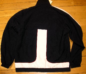 SURVÊTEMENT DE SPORT EN TISSU DE FIBRES SYNTHÉTIQUES (100% POLYESTER), NON RECONNAISSABLE COMME ÉTANT POUR HOMMES OU POUR FEMMES, COMPOSÉ D'UNE VESTE ET D'UN PANTALON :

- LA VESTE DESCEND JUSQU'AUX HANCHES ET COMPORTE UN COL MONTANT, UNE OUVERTURE COMPLÈTE SUR LE DEVANT SE FERMANT AU MOYEN D'UNE FERMETURE À GLISSIÈRE, UNE DOUBLURE COMPLÈTE EN MAILLES FILET, DES MANCHES LONGUES RESSERRÉES À LEUR EXTRÉMITÉ PAR UN BORD ÉLASTIQUE, DEUX POCHES LATÉRALES AVEC FERMETURE À GLISSIÈRE ET UN BORD ÉLASTIQUE À LA BASE. 

LA VESTE COMPORTE DES EMPIÈCEMENTS DE TISSU DE COULEUR CONTRASTÉE COUSUS LONGITUDINALEMENT SUR LE DESSUS DES MANCHES AINSI QU'AU MILIEU ET À LA BASE DU DOS. CES EMPIÈCEMENTS SONT BORDÉS PAR UN FIN GALON TRICOTÉ D'UNE AUTRE COULEUR. ON RETROUVE CE MÊME GALON BORDANT LE POURTOUR DU COL.

EN OUTRE, CETTE VESTE PRÉSENTE UNE OUVERTURE HORIZONTALE D'AÉRATION DANS LE DOS ET UN LOGO PUBLICITAIRE IMPRIMÉ SUR LA POITRINE CÔTÉ GAUCHE.

- LE PANTALON FAIT L'OBJET D'UN CLASSEMENT SÉPARÉ (CF RTC N°FR-E4-2006-000544-02).