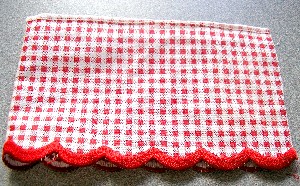 RUBAN (MOTIF VICHY) EN TISSU DE FIBRES SYNTHETIQUES (50% POLYESTER – 50% COTON) D’UNE LONGUEUR DE 2.5 M ET D’UNE LARGEUR DE 9 CM COMPORTANT SUR UN BORD UNE FAUSSE LISIERE DESTINEE A PREVENIR L’EFFILOCHAGE ET SUR L’AUTRE BORD UNE LISIERE REELLE SOUS FORME DE FESTON EN DEMI-LUNE. CE RUBAN COMPORTE SUR SA FACE INTERNE UNE PETITE BANDE ADHESIVE RECOUVERTE D’UNE BANDE PLASTIFIEE DE PROTECTION.