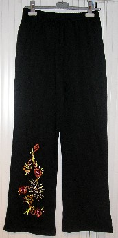 ENSEMBLE POUR FEMMES COMPOSÉ D'UN PANTALON ET D'UN VÊTEMENT DESTINÉ À RECOUVRIR LA PARTIE SUPÉRIEURE DU CORPS, DE TYPE PULL-OVER, RÉALISÉS DANS LA MÊME ÉTOFFE DE BONNETERIE DE COTON, TEINTE UNIFORMÉMENT, NON LÉGÈRE ET CONDITIONNÉS ENSEMBLE POUR LA VENTE AU DÉTAIL : 

- LE PULL-OVER DESCEND SOUS LES FESSES ET PRÉSENTE UNE ENCOLURE DE FORME ARRONDIE BORDÉE D'UN BIAIS SUR SON POURTOUR, DES MANCHES 3/4 ET UN OURLET À L'EXTRÉMITÉ DES MANCHES AINSI QU'À LA BASE.
EN OUTRE, IL PRÉSENTE TROIS LIGNES DE FLEURS BRODÉES, DE TAILLE IMPORTANTE, SUR LE DEVANT.
POIDS UNITAIRE DU VÊTEMENT POUR UNE TAILLE 42/44 : 280 GRAMMES.

- LE PANTALON EST DE FORME TROMPETTE. IL DESCEND JUSQU'AUX CHEVILLES ET COMPORTE UN BORD ÉLASTIQUE À LA TAILLE ET UN OURLET À L'EXTRÉMITÉ DES JAMBES. EN OUTRE, IL PRÉSENTE UN MOTIF BRODÉ FIGURANT DES FLEURS, DE TAILLE IMPORTANTE, SUR LA JAMBE DROITE ; CETTE BRODERIE EST SIMILAIRE À CELLES SITUÉES SUR LE PULL-OVER.

LES COMPOSANTS DE L'ENSEMBLE SONT DE MÊME STRUCTURE, STYLE, COULEUR ET COMPOSITION.