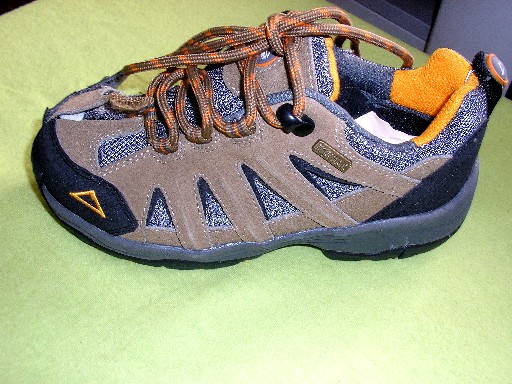 CHAUSSURE CONCUE POUR L'EXERCICE D'UNE ACTIVITE SPORTIVE, GENRE TRAINING, POUR ENFANT, NE COUVRANT PAS LA CHEVILLE, AVEC FERMETURE PAR LACETS, COMPOSEE D'UNE SEMELLE EXTERIEURE EN MATIERE PLASTIQUE QUI PRESENTE DES SCULPTURES ET DES STRIES, LA SEMELLE INTERIEURE MESURE 20.5 CM, COMPORTANT UNE COUCHE DE POLYMERE A BASSE DENSITE 0.23 GR/CM3, LE DESSUS EST EN MATIERE TEXTILE 53.6%, EN CUIR 26.8% ET EN MATIERE PLASTIQUE 19.6%, LOGO PUBLICITAIRE COUSU SUR LA LANGUETTE.
