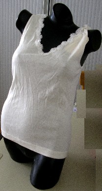 VÊTEMENT POUR FEMMES DESTINÉ À RECOUVRIR LA PARTIE SUPÉRIEURE DU CORPS, DE TYPE BLOUSE, SANS MANCHES, CONFECTIONNÉ EN ÉTOFFE DE BONNETERIE DE LAINE COMPORTANT PLUS DE 10 RANGÉES DE MAILLES AU CENTIMÈTRE LINÉAIRE, AJUSTÉE, LÉGÈRE ET DESCENDANT JUSQU'AUX HANCHES.

CETTE BLOUSE COMPORTE UNE ENCOLURE EN V TRÈS DÉCOLLETÉE BORDÉE PAR UN GALON DE DENTELLE, UN BIAIS SATINÉ SUR LE POURTOUR DES EMMANCHURES ET UN OURLET À LA BASE.