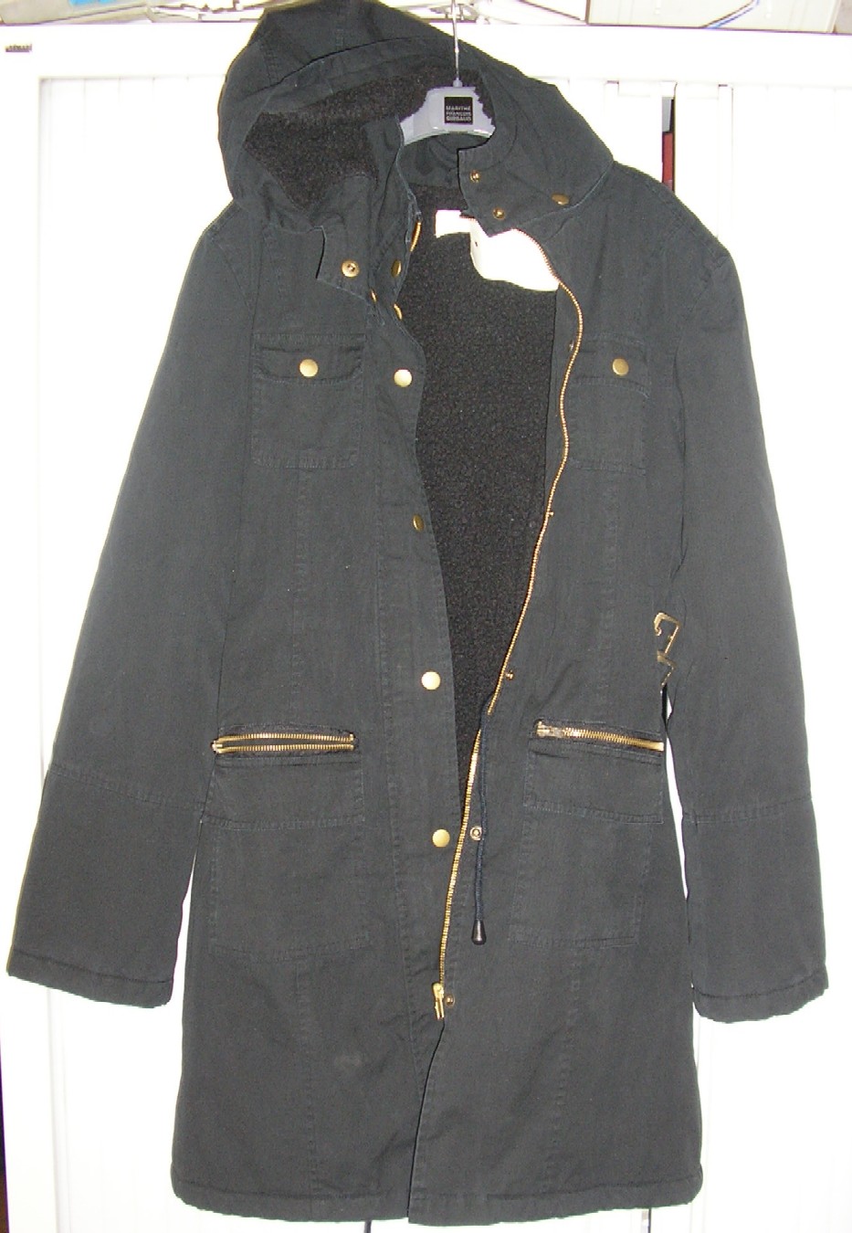 VETEMENT POUR FEMME CONFECTIONNE EN TISSU DE COTON DESTINE A RECOUVRIR LA PARTIE SUPERIEURE ET INFERIEURE DU CORPS DE TYPE PARKA (LONGUEUR BASE DU COL A LA BASE DU VETEMENT 89 CM), COMPOSE D'UNE CAPUCHE AMOVIBLE AU COL PAR BOUTONS-PRESSIONS, DE MANCHES LONGUES, D'UNE OUVERTURE COMPLETE SUR LE DEVANT AU MILIEU AVEC FERMETURE A GLISSIERE ET BOUTONS-PRESSIONS, DE TROIS POCHES DE CHAQUE COTE DU VETEMENT  DONT UNE AVEC FERMETURE A GLISSIERE, UNE AVEC FERMETURE DE BOUTONS-PRESSIONS ET UNE AVEC UN SIMPLE RABAT EN TISSU, D'UN LIEN RESSERANT AU NIVEAU DE LA TAILLE A L'INTERIEUR, DE DEUX BOUCLES AU NIVEAU DE LA TAILLE DESTINE A AJUSTER LE VETEMENT ET D'UNE DOUBLURE EN POLYSTER (100%).