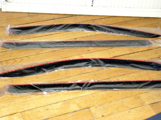 ENSEMBLE DE QUATRE DEFLECTEURS DE PORTIERE POUR AUTOMOBILE, DEUX POUR L'AVANT ET DEUX POUR L'ARRIERE, EN MATIERE PLASTIQUE (POLYMETHACRYLATE DE METHYLE), POSSEDANT CHACUN UNE BORDURE ADHESIVE.