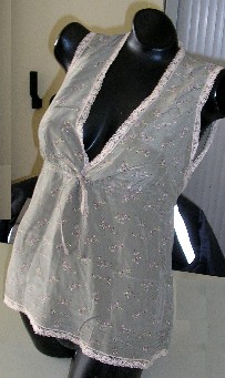 ENSEMBLE POUR FEMMES COMPOSÉ DE DEUX VÊTEMENTS RÉALISÉS DANS LE MÊME TISSU IMPRIMÉ DE SOIE, CONDITIONNÉS ENSEMBLE POUR LA VENTE AU DÉTAIL, COMPRENANT : 

- UN VÊTEMENT DESTINÉ À RECOUVRIR LA PARTIE SUPÉRIEURE DU CORPS DE TYPE BLOUSE, DESCENDANT JUSQU'AUX HANCHES, SANS MANCHES, AVEC UN PROFOND DÉCOLLETÉ EN V, AVEC UN RUBAN COULISSANT RESSERRANT SOUS LA POITRINE À NOUER SUR LE DEVANT SE PROLONGEANT DANS LE DOS PAR UNE BANDE ÉLASTIQUE, AVEC UNE RANGÉE DE CINQ NERVURES PARALLÈLES AU BAS DU VÊTEMENT ET AVEC UN GALON DE DENTELLE BORDANT LE POURTOUR DES EMMANCHURES, DE L'ENCOLURE ET DE LA BASE.

- UN PANTALON DESCENDANT JUSQU'À MI-MOLLET, GENRE PANTACOURT, DE COUPE LARGE ET DROITE, SANS OUVERTURE, AVEC UN BORD ÉLASTIQUE À LA TAILLE, AVEC UN RUBAN COULISSANT À NOUER SUR LE DEVANT, AVEC UNE RANGÉE DE CINQ PETITES NERVURES PARALLÈLES À L'EXTRÉMITÉ DES JAMBES ET AVEC UN GALON DE DENTELLE À LA BASE.

LES COMPOSANTS DE L'ENSEMBLE SONT DE MÊME STRUCTURE, STYLE, COULEUR ET COMPOSITION.