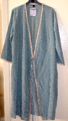 VÊTEMENT POUR FEMMES COUVRANT LE HAUT ET LE BAS DU CORPS EN TISSU DE SOIE IMPRIMÉ, DE TYPE DÉSHABILLÉ OU PEIGNOIR, DE FORME CINTRÉE, DESCENDANT JUSQU'AUX GENOUX, COMPORTANT DES MANCHES 3/4, UNE RANGÉE DE CINQ NERVURES AU BAS DES MANCHES, UNE OUVERTURE COMPLÈTE SUR LE DEVANT SE FERMANT DROITE SUR GAUCHE PAR DEUX LIENS À NOUER FAÇON CACHE-CŒUR ET DEUX POCHES FENDUES LATÉRALES SITUÉES AU-DESSOUS DE LA TAILLE.

LE POURTOUR DE L'OUVERTURE ET L'EXTRÉMITÉ DES MANCHES SONT BORDÉS PAR UN GALON DE DENTELLE RAPPORTÉ. LA BASE EST OURLÉE.