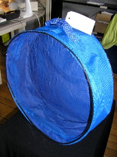 SAC EN MATIERE TEXTILE 60% NYLON ET EN MATIERE PLASTIQUE 40% PVC, DE FORME RONDE, AVEC UNE POIGNEE, UNE OUVERTURE AVEC FERMETURE A GLISSIERE, LA FACE DU DESSUS EST EN MATIERE PLASTIQUE TRANSPARENTE.