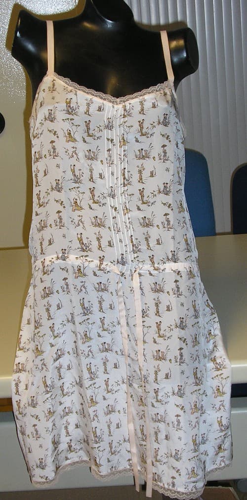 ROBE POUR FEMMES EN TISSU SATINÉ DE SOIE, IMPRIMÉ, DESCENDANT JUSQU'AUX GENOUX, SANS MANCHES, AVEC UNE ENCOLURE LÉGÈREMENT EN V DÉCOLLETÉE, AVEC UN BIAIS ASPECT DENTELLE DE COULEUR CONTRASTÉE SUR TOUT LE POURTOUR DU HAUT ET DE LA BASE, AVEC DE FINES BRETELLES RÉGLABLES DE LA MÊME COULEUR QUE LE BIAIS, AVEC UN CORDON RESSERRANT AU NIVEAU DE LA TAILLE À NOUER SUR LE DEVANT DE LA MÊME MATIÈRE ET COULEUR QUE LES BRETELLES.