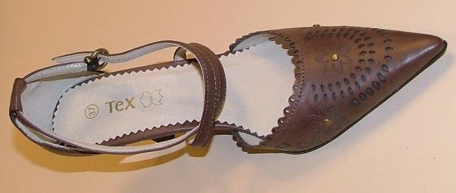 CHAUSSURE POUR FEMMES, À SEMELLE EXTÉRIEURE ET DESSUS EN MATIÈRE PLASTIQUE, AVEC UNE SEMELLE INTÉRIEURE EN CUIR NATUREL D'UNE LONGUEUR EXCÉDANT 24 CM ET AVEC UN TALON DE 4,5 CM DE HAUTEUR.

CETTE CHAUSSURE PRÉSENTE LA FORME D'UN ESCARPIN AVEC UNE CLAQUE FERMÉE À BOUT POINTU AU BORD DENTELÉ ET UNE PARTIE COUVRANT UNIQUEMENT LE TALON. EN OUTRE, ELLE EST POURVUE DE DEUX BRIDES, PERMETTANT DE MAINTENIR LA CHAUSSURE EN PLACE, SE CROISANT SUR LE PIED ET S'ATTACHANT AU MOYEN D'UNE BOUCLE EN MÉTAL SITUÉE AU NIVEAU DE LA CHEVILLE.