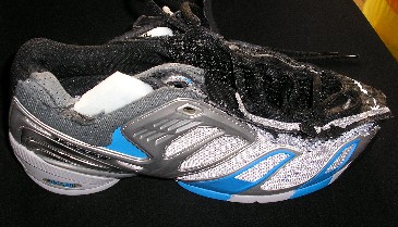 CHAUSSURE DESTINÉE À L'ACTIVITÉ SPORTIVE, NON RECONNAISSABLE COMME ÉTANT POUR HOMMES OU POUR FEMMES, AVEC UNE SEMELLE EXTÉRIEURE EN CAOUTCHOUC ET UN DESSUS MAJORITAIREMENT EN MATIÈRE PLASTIQUE (54% MATIÈRE PLASTIQUE - 46% TEXTILE), NE COUVRANT PAS LA CHEVILLE, AVEC UNE SEMELLE INTÉRIEURE D'UNE LONGUEUR SUPÉRIEURE À 24 CM. 

CETTE CHAUSSURE COMPORTE UNE OUVERTURE SUR LE DESSUS POURVUE D'UNE LANGUETTE REMBOURRÉE SE FERMANT PAR DES LACETS AINSI QUE PAR UNE LANIÈRE AGRIPPANTE. LA SEMELLE EXTÉRIEURE EST POURVUE DE SCULPTURES ANTIDÉRAPANTES ET REMONTE SUR LA POINTE.

EN OUTRE, CETTE CHAUSSURE PRÉSENTE LES CARACTÉRISTIQUES D'UNE CHAUSSURE À TECHNOLOGIE SPÉCIALE : LA SEMELLE EXTÉRIEURE EST CONSTITUÉE DE PLUSIEURS COUCHES DE POLYMÈRES À BASSE DENSITÉ (DENSITÉ INFÉRIEURE À 0,6 GRAMMES PAR CM3).