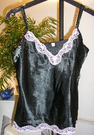 LOT DE DEUX SOUS-VÊTEMENTS POUR FEMMES COMPOSÉ D'UN CARACO ET D'UNE CULOTTE, CONFECTIONNÉS EN TISSU D'ASPECT SATINÉ DE FIBRES SYNTHÉTIQUES (100% POLYESTER) TEINT UNIFORMÉMENT, CONDITIONNÉS ENSEMBLE POUR LA VENTE AU DÉTAIL :

- CARACO, DESTINE A COUVRIR LA PARTIE SUPERIEUR DU CORPS, IL DESCEND JUSQU'AU-DESSOUS DE LA TAILLE ET COMPORTE UNE ENCOLURE EN « V » TRÈS DÉCOLLETÉE SUR LE DEVANT, AVEC DE FINES BRETELLES RÉGLABLES ET UN GALON EN DENTELLE DE COULEUR CONTRASTÉE RAPPORTÉ SUR LE POURTOUR DE L'ENCOLURE ET A LA BASE DU VÊTEMENT.

- CULOTTE, AVEC UN ÉLASTIQUE À LA TAILLE ET UN LIEN A NOUER DÉCORATIF SUR LE DEVANT, AVEC DEUX FENTES LATÉRALES SUR LES COTES, AVEC UN GALON EN DENTELLE SUR LE POURTOUR A LA BASE DES JAMBES DE COULEUR IDENTIQUE A CELLE DU CARACO.