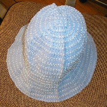 CHAPEAU SOUS LA FORME D’UNE CLOCHE, CONFECTIONNE EN TISSU DE FIBRES SYNTHETIQUES (100% POLYESTER) FABRIQUE PAR L’ASSEMBLAGE DE BANDES DOTEES DE SURPIQURES.