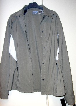 VESTE MAJORITAIREMENT EN TISSU DE FIBRES SYNTHETIQUES (86 % POLYESTER - 14 % ELASTHANNE) AVEC CERTAINS EMPIECEMENTS EN BONNETERIE (STYLE FILET) COMPORTANT SIX PANNEAUX FRONTAUX ET TROIS PANNEAUX DORSAUX COUSUS ENSEMBLE DANS LE SENS DE LA LONGUEUR, UN COL, DES MANCHES LONGUES AVEC A LEURS EXTREMITES DEUX BOUTONS, UNE OUVERTURE COMPLÈTE SUR LE DEVANT SE FERMANT CÔTE DROIT SUR GAUCHE AVEC DES BOUTONS PRESSION, DEUX POCHES LATERALES A LA BASE DOTEES D'UNE FERMETURE A GLISSIERE ET DEUX PETITES FENTES DORSALES DE 5 CENTIMETRES DE LONGUEUR EN PARTANT DE LA BASE.