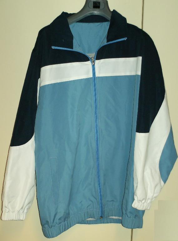 SURVÊTEMENT DE SPORT EN TISSU DE FIBRES SYNTHÉTIQUES (100% POLYESTER), NON RECONNAISSABLE COMME ÉTANT POUR HOMMES OU POUR FEMMES, COMPOSÉ D'UNE VESTE ET D'UN PANTALON : 

- LA VESTE DESCEND JUSQU'AUX HANCHES ET COMPORTE UN COL MONTANT, UNE OUVERTURE COMPLÈTE SUR LE DEVANT SE FERMANT AU MOYEN D'UNE FERMETURE À GLISSIÈRE, UNE DOUBLURE COMPLÈTE EN MAILLES FILET, DES MANCHES LONGUES RESSERRÉES À LEUR EXTRÉMITÉ PAR UN BORD ÉLASTIQUE, DEUX POCHES LATÉRALES SANS SYSTÈME DE FERMETURE ET UN BORD ÉLASTIQUE À LA BASE. 

ELLE COMPORTE ÉGALEMENT DES EMPIÈCEMENTS DE TISSU, DE DEUX COULEURS CONTRASTÉES, AU NIVEAU DES MANCHES ET DU HAUT. 

- LE PANTALON FAIT L'OBJET D'UN CLASSEMENT SÉPARÉ REPRIS AU RTC N°FR-E4-2007-000025-02.