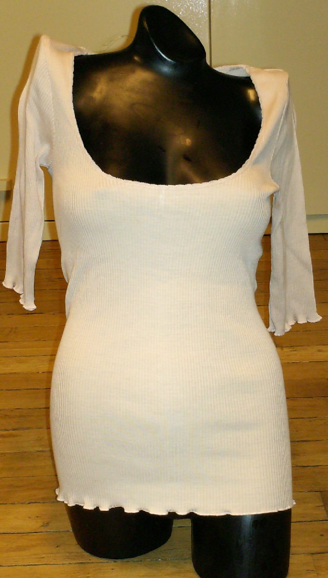 VÊTEMENT POUR FEMMES, DU TYPE BLOUSE, EN ÉTOFFE DE BONNETERIE LÉGÈRE MAJORITAIREMENT DE SOIE (70% SOIE – 30% COTON), UNICOLORE, DESTINÉ À RECOUVRIR LA PARTIE SUPÉRIEURE DU CORPS, DESCENDANT JUSQU'AUX HANCHES, AVEC UNE ENCOLURE RONDE TRÈS DÉCOLLETÉE, AVEC DES MANCHES COURTES, AVEC UN OURLET ROULOTTÉ À LA BASE ET À L'EXTRÉMITÉ DES MANCHES.