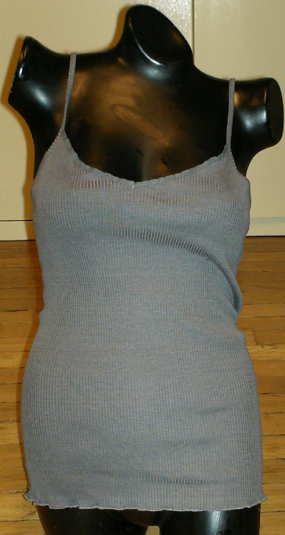 MAILLOT DE CORPS UNICOLORE CONFECTIONNÉ EN ÉTOFFE DE BONNETERIE LÉGÈRE MAJORITAIREMENT DE SOIE (70% SOIE – 30% COTON), DESCENDANT JUSQU'AUX HANCHES, AVEC UNE ENCOLURE EN V DÉCOLLETÉE, SANS MANCHES, AVEC DE FINES BRETELLES RÉGLABLES, AVEC UN OURLET ROULOTTÉ À LA BASE.