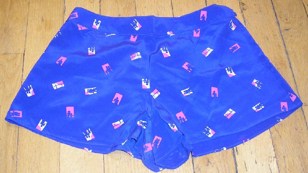 PETIT SHORT D'INTÉRIEUR  POUR FEMMES, IMPRIMÉ, EN TISSU DE SOIE, LÉGER, AVEC UNE  OUVERTURE PARTIELLE À LA TAILLE SUR LE CÔTÉ GAUCHE FERMANT AU MOYEN DE DEUX BOUTONS, AVEC UN BORD ÉLASTIQUE DANS LE DOS À LA TAILLE, AVEC UN OURLET À LA BASE.