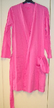 VÊTEMENT POUR FEMMES DESTINÉ À RECOUVRIR LES PARTIES SUPÉRIEURE ET INFÉRIEURE DU CORPS, SIMILAIRE À UN PEIGNOIR OU À UNE VESTE D’INTÉRIEUR, CONFECTIONNÉ EN ÉTOFFE DE BONNETERIE 100% COTON, À MAILLES FINES, TEINTE UNIFORMÉMENT, ET DESCENDANT JUSQU'AUX GENOUX. 

CE PEIGNOIR PRÉSENTE UNE OUVERTURE COMPLÈTE SUR LE DEVANT, DES MANCHES LONGUES OURLÉES À LEUR EXTRÉMITÉ, UNE CEINTURE AU NIVEAU DE LA TAILLE RELIÉE AU VÊTEMENT PAR DEUX PASSANTS ET DEUX POCHES LATÉRALES PLAQUÉES SUR LE DEVANT.

LA BASE EST OURLÉE.