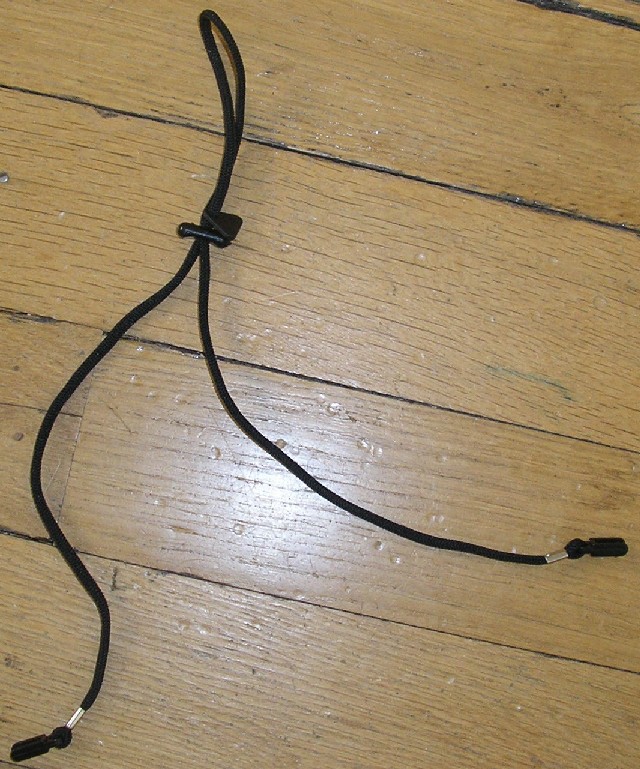 CORDON DE LUNETTES CONFECTIONNÉ EN ÉTOFFE DE BONNETERIE ET MUNI D'EMBOUTS CAOUTCHOUC À SES EXTRÉMITÉS QUI PERMETTENT LA FIXATION AUX BRANCHES DE LUNETTES.