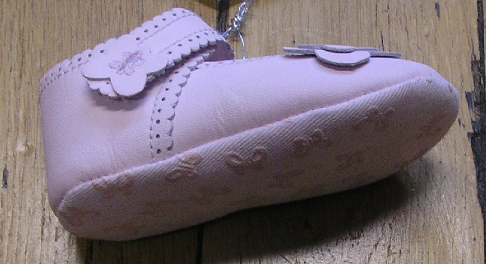 CHAUSSURE POUR BÉBÉ AYANT LA FORME D'UNE BALLERINE, AVEC UN DESSUS EN CUIR, AVEC UNE SEMELLE EXTÉRIEURE RAPPORTÉE EN MATIÈRE TEXTILE, AVEC UNE DOUBLURE COMPLÈTE EN MATIÈRE TEXTILE, AVEC UNE LANIÈRE SUR LE DESSUS PERMETTANT UNE BONNE FIXATION AU PIED, AVEC UN MOTIF EN FORME DE PAPILLON EN CUIR COUSU SUR LE CÔTÉ.