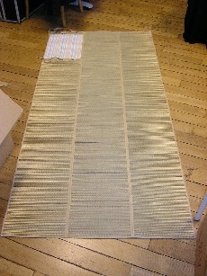 NATTE DE PLAGE, EN PAILLE, PLIABLE, COMPORTANT UNE DOUBLURE PARTIELLE EN TISSU DE COTON, SERVANT DE RANGEMENT A UN COUSSIN, AVEC ANSES ET LIENS A NOUER, LES BORDURES SONT ARRETEES PAR UN BIAIS EN TISSU.

CET ARTICLE EST ACCOMPAGNE D'UN SAC FAISANT L'OBJET D'UN CLASSEMENT SEPARE FR-E4-2007-000943-02, ET D'UN COUSSIN FAISANT L'OBJET D'UN CLASSEMENT SEPARE FR-E4-2007-000943-03.