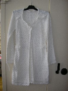 VETEMENT DESTINE A RECOUVRIR LA PARTIE SUPERIEURE DU CORPS, GENRE MANTEAU, POUR FEMMES, EN BONNETERIE 100% ACRYLIQUE, ASPECT TRICOT AU CROCHET, SANS DOUBLURE, MESURANT 95 CM DE LONGUEUR, COMPORTANT UNE ENCOLURE ARRONDIE, UNE OUVERTURE COMPLÈTE SUR LE DEVANT SE FERMANT DE DROITE SUR GAUCHE PAR DES BOUTONS, DES MANCHES LONGUES, UNE MARTINGALE AVEC DEUX BOUTONS DE CHAQUE COTE DU VETEMENT AU NIVEAU DE LA TAILLE.