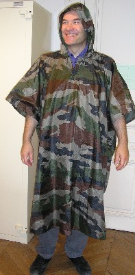 VETEMENT POUR HOMME, DU STYLE PONCHO, EN TISSU DE FIBRES SYNTHETIQUES (NYLON) ENDUIT DE MATIERE PLASTIQUE (PVC) DE FACON PERCEPTIBLE A L'OEIL NU SUR LA FACE INTERNE, DESTINE A COUVRIR LA PARTIE SUPERIEURE DU CORPS, DESCENDANT JUSQU'AUX MOLLETS, AVEC UN CAPUCHON FIXE DOTE SUR SON POURTOUR D’UN CORDON COULISSANT RESSERRANT, AVEC UNE OUVERTURE PARTIELLE SUR LE DEVANT SE FERMANT GAUCHE SUR DROITE A L’AIDE DE BOUTONS-PRESSION, AVEC UNE OUVERTURE TOTALE SUR LES COTES SE FERMANT A L’AIDE DE BOUTONS-PRESSION SUR TOUTE LA LONGUEUR, AVEC UN OURLET A LA BASE.

CE PONCHON EST PLIE ET PLACE DANS UN SAC EN PLASTIQUE SE FERMANT A L’AIDE D’UNE FERMETURE A GLISSIERE.