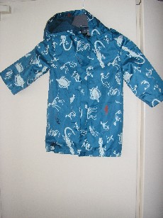 VETEMENT DESTINE A RECOUVRIR LA PARTIE SUPERIEURE DU CORPS, GENRE IMPERMEABLE, EN TISSU 100% NYLON, NON RECONNAISSABLE COMME ETANT POUR GARCONS OU POUR FILLES, COMPORTANT UNE CAPUCHE ENTIEREMENT DOUBLEE, UNE OUVERTURE COMPLETE SUR LE DEVANT AU MILIEU AVEC UNE FERMETURE A GLISSIERE, DES MANCHES LONGUES, LA BASE DU VETEMENT EST OURLEE, AVEC UNE MARTINGALE DANS LE DOS, UNE PATTE AVEC BOUTON SUR CHAQUE EPAULE, UNE FENTE AU BAS DU DOS, ENTIEREMENT DOUBLE EN BONNETERIE DE FIBRES SYNTHETIQUES, ASPECT FILET, MOTIFS IMPRIMES SUR L'ENSEMBLE DU VETEMENT.