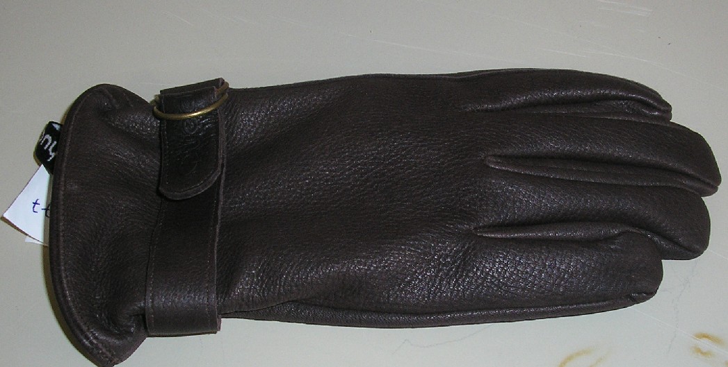 GANT UNICOLORE, NON RECONNAISSABLE COMME ÉTANT POUR HOMMES OU POUR FEMMES, EN CUIR, ÉLASTIQUÉ AU NIVEAU DU POIGNET CÔTÉ PAUME ET COMPORTANT UNE PATTE DE SERRAGE SUR LE DESSUS DU POIGNET RÉGLABLE AU MOYEN D'UNE BOUCLE MÉTALLIQUE.