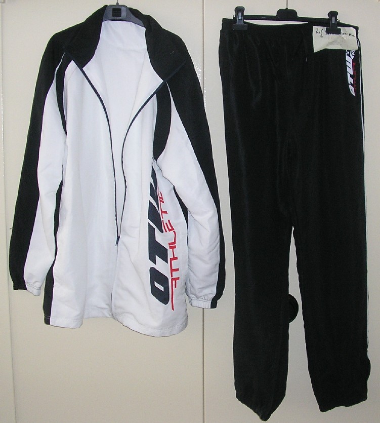 SURVÊTEMENT DE SPORT EN TISSU DE FIBRES SYNTHÉTIQUES (100% POLYESTER), NON RECONNAISSABLE COMME ÉTANT POUR HOMMES OU POUR FEMMES, COMPOSÉ D'UNE VESTE ET D'UN PANTALON : 

- LA VESTE DESCEND JUSQU'AU DESSOUS DES HANCHES ET COMPORTE UN COL MONTANT, UNE OUVERTURE COMPLÈTE SUR LE DEVANT SE FERMANT AU MOYEN D'UNE FERMETURE À GLISSIÈRE, UNE DOUBLURE COMPLÈTE EN MAILLES FILET, DES MANCHES LONGUES RESSERRÉES À LEUR EXTRÉMITÉ PAR UN BORD ÉLASTIQUE, DEUX POCHES LATÉRALES SANS SYSTÈME DE FERMETURE, UN MOTIF IMPRIMÉ SUR LE DEVANT À GAUCHE ET UN OURLET À LA BASE. 

ELLE COMPORTE ÉGALEMENT DES EMPIÈCEMENTS DE TISSU, DE  COULEUR CONTRASTÉE, COUSUS SUR LA LONGUEUR DES MANCHES, LES CÔTÉS ET LE COL. 

- LE PANTALON FAIT L'OBJET D'UN CLASSEMENT SÉPARÉ REPRIS AU RTC N°FR-E4-2007-002272-02.