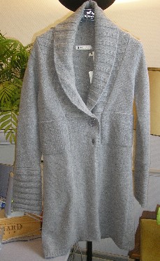 VETEMENT POUR FEMME, STYLE MANTEAU, CONFECTIONNE EN ETOFFE DE BONNETERIE DE LAINE (80% LAINE – 20% POLYAMIDE), DESTINE A COUVRIR LA PARTIE SUPERIEURE DU CORPS, DESCENDANT JUSQU’AU DESSUS DES GENOUX, SANS DOUBLURE, AVEC UN GRAND COL CHALE, AVEC DES MANCHES LONGUES, AVEC UNE OUVERTURE COMPLETE SUR LE DEVANT SE FERMANT DROITE SUR GAUCHE A L’AIDE DE BOUTONS. LE COL, L’EXTEMITE DES MANCHES ET LA BASE DU VETEMENT SONT EN BORD-COTES.

LONGUEUR DOS : 90 CM ENVIRON