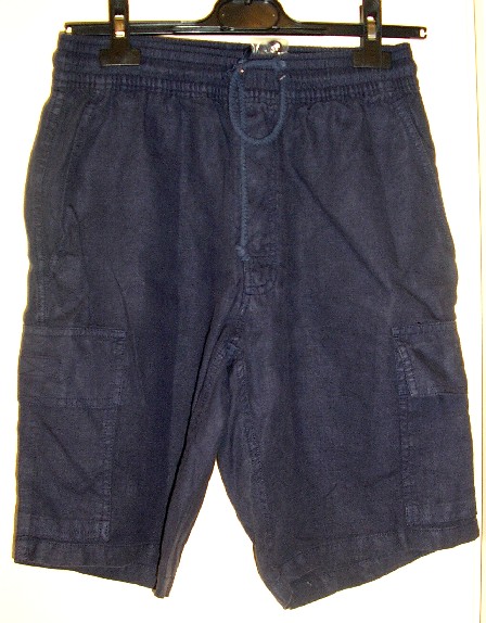 VÊTEMENT DESTINÉ À RECOUVRIR LA PARTIE INFÉRIEURE DU CORPS, DE TYPE BERMUDA, CONFECTIONNÉ EN TISSU 100% LIN, TEINT UNIFORMÉMENT, DESCENDANT JUSQU'AU-DESSUS DES GENOUX. 

CE VÊTEMENT COMPORTE UNE LARGE BANDE ÉLASTIQUE AINSI QU'UN CORDON COULISSANT À LA TAILLE, UNE OUVERTURE PARTIELLE SUR LE DEVANT SE FERMANT GAUCHE SUR DROITE AU MOYEN DE TROIS BOUTONS EN PLASTIQUE, DEUX POCHES FENDUES LATÉRALES SITUÉES SOUS LA TAILLE, DEUX POCHES PLAQUÉES SE FERMANT PAR UN RABAT AVEC VELCRO SITUÉES SUR LES CUISSES ET UNE POCHE ARRIÈRE SE FERMANT PAR UN RABAT AVEC VELCRO.

LA BASE DU BERMUDA EST OURLÉE.

CE BERMUDA EST CONDITIONNÉ POUR LA VENTE AU DÉTAIL ACCOMPAGNÉ D'UNE HOUSSE PROTECTRICE EN TISSU QUI FAIT L'OBJET D'UN CLASSEMENT SÉPARÉ (CF RTC N°FR-E4-2007-002549-02).