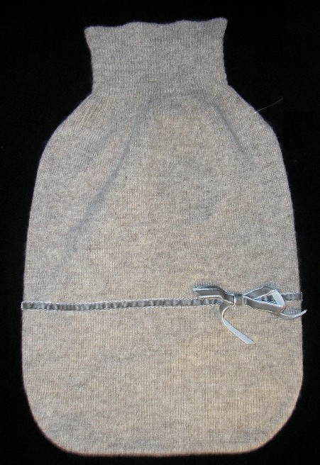 HOUSSE DE BOUILLOTTE CONFECTIONNÉE EN ÉTOFFE DE BONNETERIE DE POILS FINS (100% CACHEMIRE) POURVUE D'UNE OUVERTURE RESSERRÉE PAR UN BORD-CÔTE ET PRÉSENTANT UN GALON DE VELOURS FORMANT UN NŒUD DÉCORATIF.