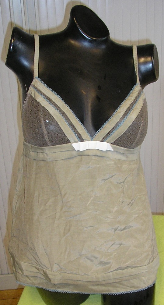 VÊTEMENT POUR FEMMES, TYPE CARACO, CONFECTIONNÉ MAJORITAIREMENT EN COTON (53% COTON, 35% SOIE ET 12% POLYAMIDE), LÉGER, DE FORME ÉVASÉE VERS LA BASE, DESTINÉ À RECOUVRIR LA PARTIE SUPÉRIEURE DU CORPS, DESCENDANT JUSQU'AUX HANCHES, AVEC UNE ENCOLURE EN V TRÈS DÉCOLLETÉE SUR LE DEVANT COMPORTANT UN NOEUD DÉCORATIF EN SON CENTRE ET BORDÉE D'UN GALON ASPECT DENTELLE, AVEC DES BONNETS CONFECTIONNÉS DANS UNE MATIÈRE ASPECT TULLE TRANSPARENTE, AVEC UNE ENCOLURE TRÈS DÉCOLLETÉE DANS LE DOS BORDÉE D'UNE BANDE ÉLASTIQUÉE, AVEC DE FINES BRETELLES RÉGLABLES, AVEC UN OURLET À LA BASE BORDÉ D'UN FIN GALON ASPECT DENTELLE.