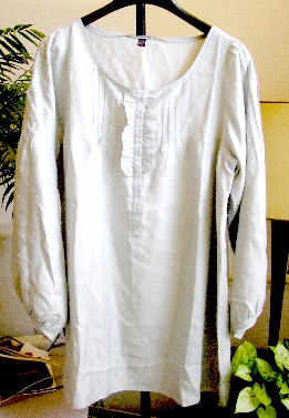 VETEMENT POUR FEMME, GENRE BLOUSE, DE FACTURE AMPLE, EN TISSU DE SOIE (100% SOIE), COUVRANT LA PARTIE SUPERIEURE DU CORPS, DESCENDANT JUSQU’AUX HANCHES, AVEC UNE ENCOLURE ARRONDIE DECOLLETEE DOTEE D’UN BIAIS SUR SON POURTOUR, AVEC UNE OUVERTURE PARTIELLE SUR LE DEVANT SE FERMANT DROITE SUR GAUCHE A L’AIDE DE BOUTONS. CETTE OUVERTURE PRESENTE DE CHAQUE COTE DES NERVURES ET UN VOLANT FORMANT JABOT, AVEC DES MANCHES LONGUES DOTEES DE NERVURES SUR LE DESSUS ET D’UN BIAIS A LEURS EXTREMITES, AVEC UN OURLET A LA BASE.