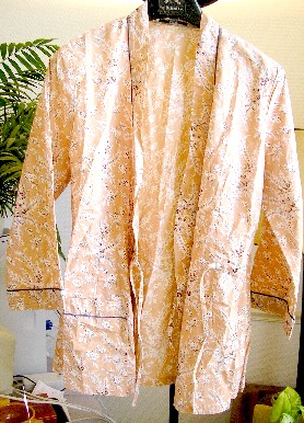VETEMENT POUR FEMME, SIMILAIRE A UN DESHABILLE, EN TISSU DE COTON (100% COTON), DESTINE A COUVRIR LA PARTIE SUPERIEURE DU CORPS, DESCENDANT JUSQU’AUX HANCHES, DE FORME KIMONO, AVEC UNE ENCOLURE EN « V », AVEC UNE OUVERTURE COMPLETE SUR LE DEVANT SE FERMANT DROITE SUR GAUCHE EN S’ATTACHANT A DROITE AU MOYEN D’UN LIEN A NOUER, AVEC UN LIEN A NOUER A L’INTERIEUR PERMETTANT DE NOUER ET MAINTENIR LE PANNEAU GAUCHE, AVEC DES MANCHES LONGUES POURVUES A LEURS EXTREMITES D’UN REVERS GARNI DE LISERE, AVEC UNE POCHE SUR LE PANNEAU DROIT, AVEC UN OURLET A LA BASE DU VETEMENT.

LE POURTOUR DE L’ENCOLURE ET LES PANNEAUX DU DEVANT SONT DOTES D’UNE BANDE RAJOUTEE ET D’UN LISERE.