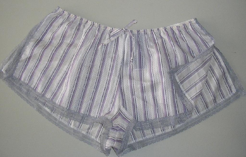 VÊTEMENT POUR FEMMES EN TISSU DE COTON IMPRIMÉ, DU TYPE CULOTTE À TAILLE HAUTE, AVEC UNE TAILLE ÉLASTIQUÉE COMPORTANT UN NOEUD DÉCORATIF AU MILIEU SUR LE DEVANT, AVEC DEUX FENTES LATÉRALES SUR PRESQUE TOUTE LA HAUTEUR DU VÊTEMENT, AVEC UN BIAIS ASPECT DENTELLE DE COULEUR CONTRASTÉE SUR TOUT LE POURTOUR DU VÊTEMENT SAUF AU NIVEAU DE LA TAILLE.