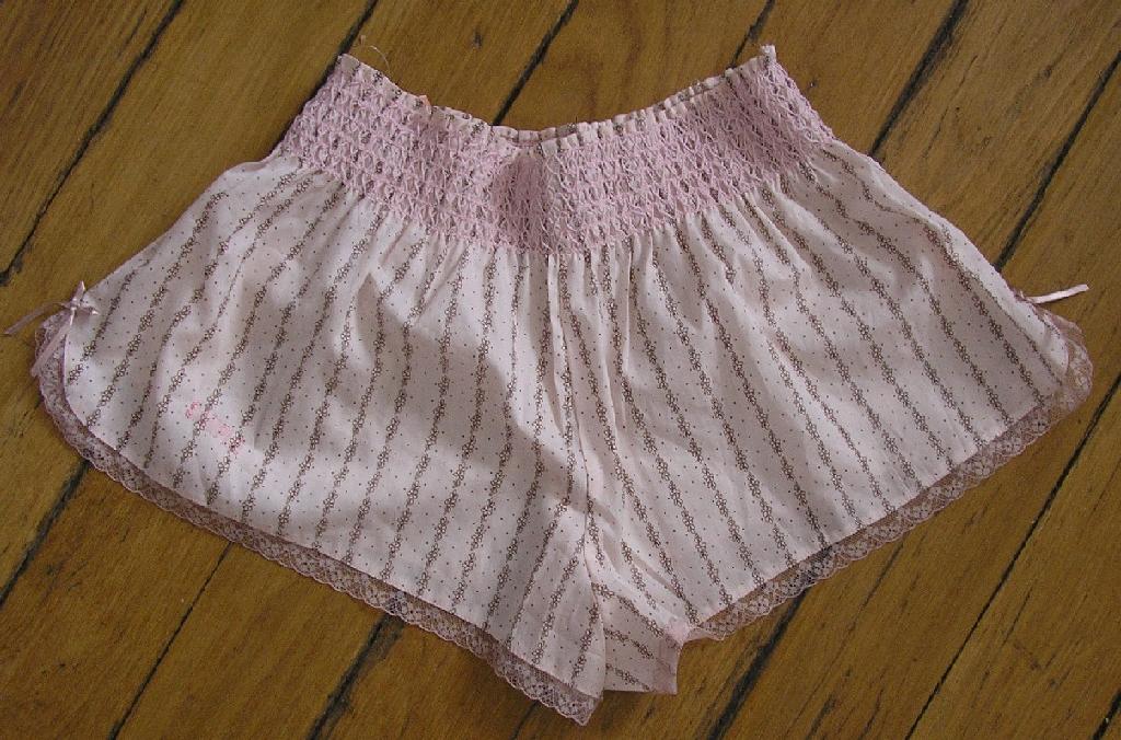 CULOTTE À TAILLE HAUTE POUR FEMMES, DU TYPE SHORTY, EN TISSU DE COTON IMPRIMÉ, AVEC UNE TAILLE SMOKÉE NE COMPORTANT AUCUNE OUVERTURE, AVEC UN PETIT NŒUD DÉCORATIF DE CHAQUE CÔTÉ À LA BASE, AVEC UN BIAIS ASPECT DENTELLE SUR TOUT LE POURTOUR DU VÊTEMENT SAUF AU NIVEAU DE LA TAILLE, AVEC UNE DOUBLURE À L'ENTREJAMBE.
