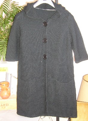 VETEMENT POUR FEMME, STYLE MANTEAU, CONFECTIONNE EN ETOFFE DE BONNETERIE TRICOTE POINT MOUSSE (60% COTON – 40% LYCRA), AVEC UN CAPUCHON FIXE, AVEC DES MANCHES 3/4 MUNIES D’UN BORD-COTES A LEURS EXTREMITES, AVEC UNE OUVERTURE COMPLETE SUR LE DEVANT SE FERMANT DROITE SUR GAUCHE A L’AIDE DE BOUTONS, AVEC UNE POCHE PLAQUEE DE CHAQUE COTE, SANS DOUBLURE, AVEC UN BORD-COTES A LA BASE.

CE VETEMENT DESCEND AU DESSOUS DE LA MI-CUISSES.
LONGUEUR DOS : 88 CM ENVIRON