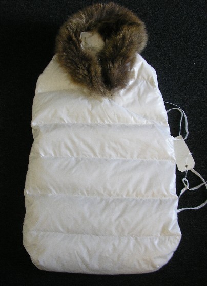NID D’ANGE, SE PRESENTANT SOUS LA FORME D’UN SAC DE COUCHAGE, CONFECTIONNE EN TISSU DE NYLON (100% NYLON), ENTIEREMENT OUATINE, SANS MANCHES, AVEC UN CAPUCHON FIXE DOTE SUR SON POURTOUR D’UNE BANDE DE FOURRURE, AVEC UNE OUVERTURE PARTIELLE SUR LE COTE. CE VETEMENT SE CROISE SUR LE DEVANT ET SE FERME A L’INTERIEUR A L’AIDE D’UN BOUTON-PRESSION ET SUR L’EXTERIEUR A L’AIDE DE DEUX LIENS A NOUER.

HAUTEUR : 70 CM