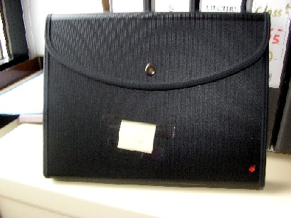 PORTE-DOCUMENTS DONT LA SURFACE EXTERIEURE EST EN MATIERE PLASTIQUE(PROLYPROPYLENE), EN FORME DE CARTABLE, COMPORTANT UN RABAT ET UNE FERMETURE PAR BOUTON-PRESSION, DES SOUFFLETS AVEC PORTE-ETIQUETTE, DES POCHES AVEC FERMETURE A GLISSIERE, DES COMPARTIMENTS POUR STYLO, UNE POIGNEE ELASTIQUE, LOGO PUBLICITAIRE IMPRIME SUR LA FACE EXTERIEURE.