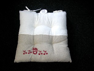 COUSSIN DE CHAISE EN MATERE TEXTILE REMBOURRÉE (TISSU DE FIBRES VEGETALES : 55% LIN-45% VISCOSE), DE FORME CARRÉE (38X38 CM) , AVEC DES LIENS A NOUER SUR UN COTE, UNE FACE BICOLORE ET DES DESSINS SURPIQUES DE COULEUR CONTRASTEE.