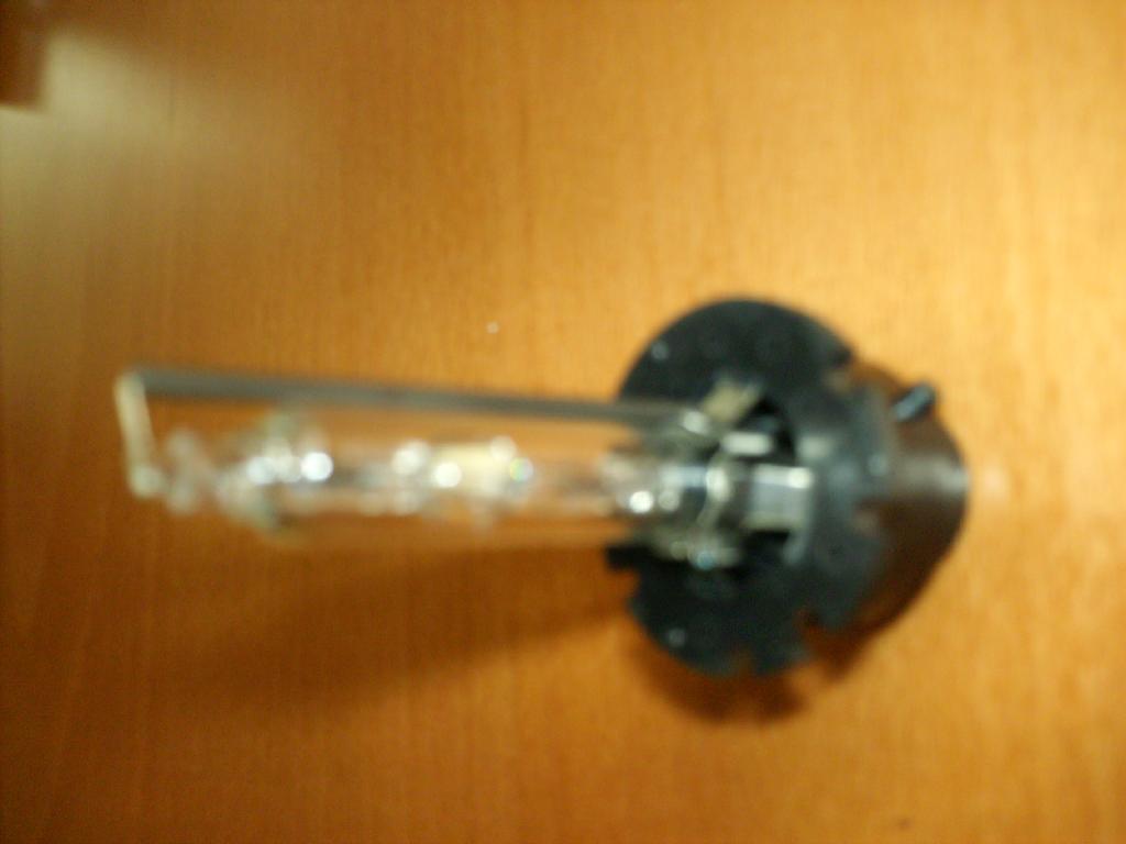 LAMPE A DECHARGE POUR PROJECTEUR AUTOMOBILE SE PRESENTANT SOUS LA FORME D'UN TUBE CONTENANT UN GAZ (XENON) SOUS HAUTE PRESSION AINSI QUE DES HALOGENURES METALLIQUES.
L'ENERGIE RESULTANT DU DEPLACEMENT DES ELECTRONS EST EMISE DIRECTEMENT SOUS FORME DE PHOTONS (LUMIERE VISIBLE).
LA LAMPE NE CONTIENT PAS DE MERCURE ET LE TUBE N'EST PAS RECOUVERT DE SUBSTANCES LUMINESCENTES NI FLUORESCENTES.
ELLE EST ALIMENTEE SOUS UNE TENSION DE 42 V PAR L'INTERMEDIAIRE D'UN SYSTEME ELECTRONIQUE AUXILIAIRE, ELEVATEUR DE TENSION IMPLANTE SUR LE VEHICULE ENTRE LA BATTERIE ET LA LAMPE (NON FOURNI).
SA PUISSANCE ELECTRIQUE EST DE 35 W.